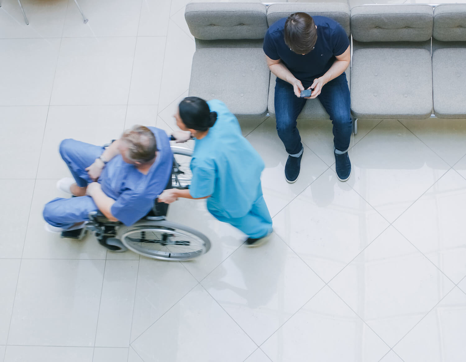 doctor pushing patient through hospital in wheelchair