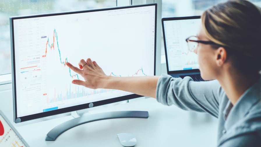 woman pointing to data on monitor