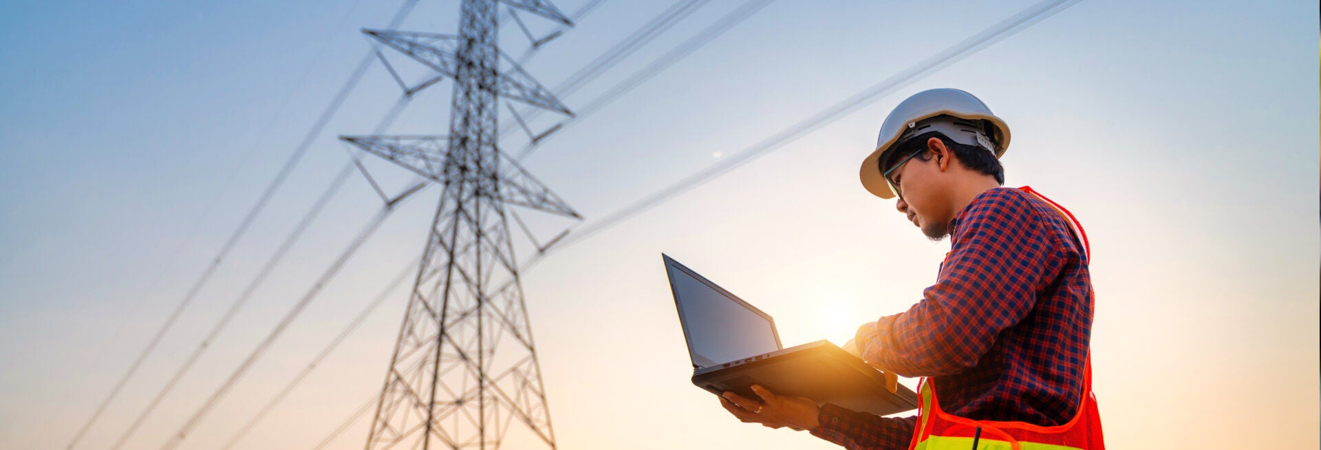 worker wearing hard hat and using laptop