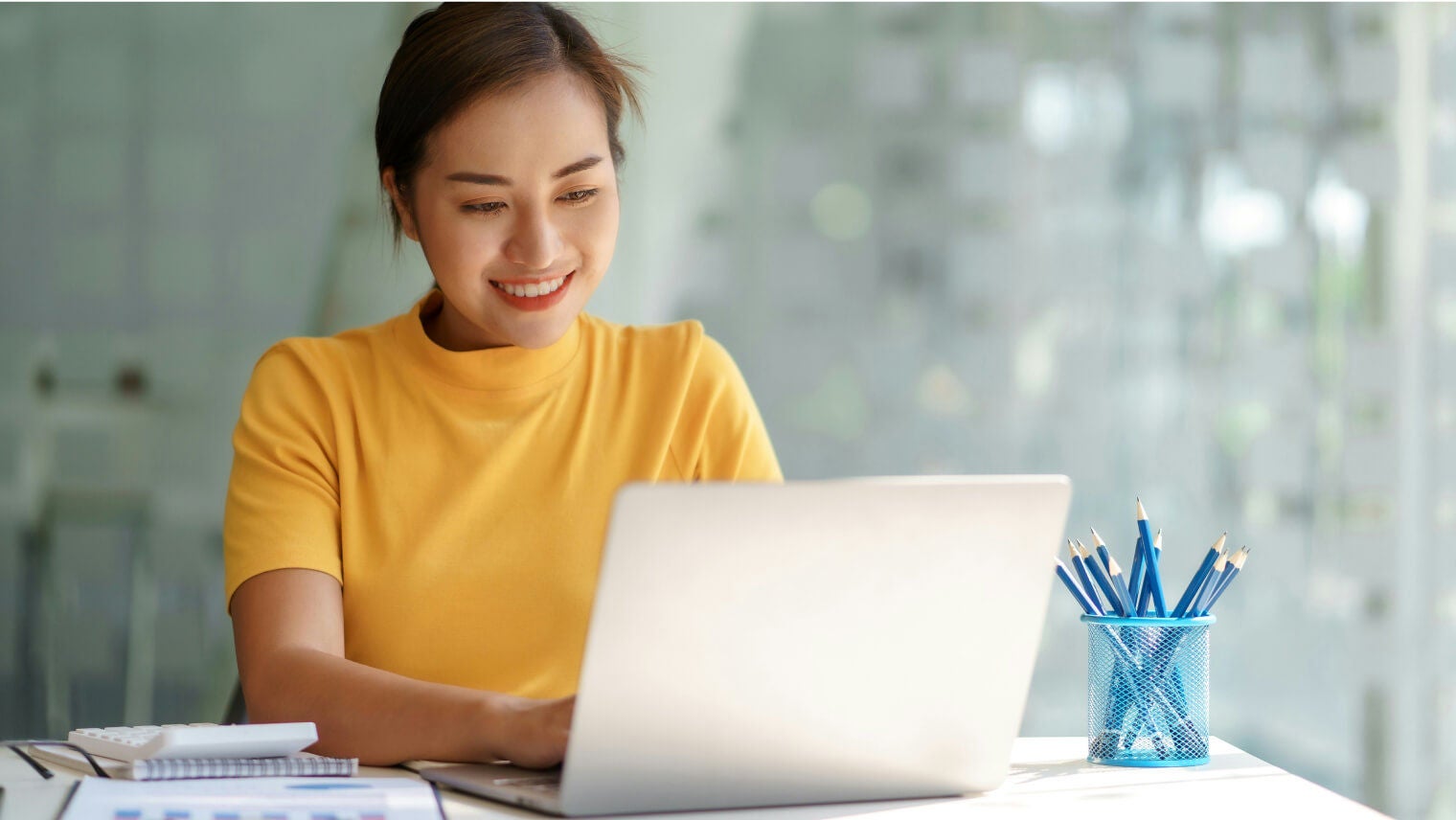 Woman smiling while working on a laptop
