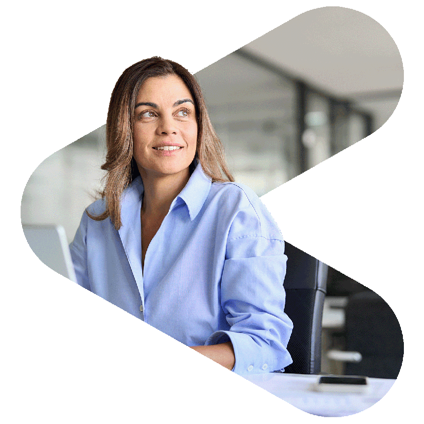 office worker using laptop at desk but looking out the widow to her left